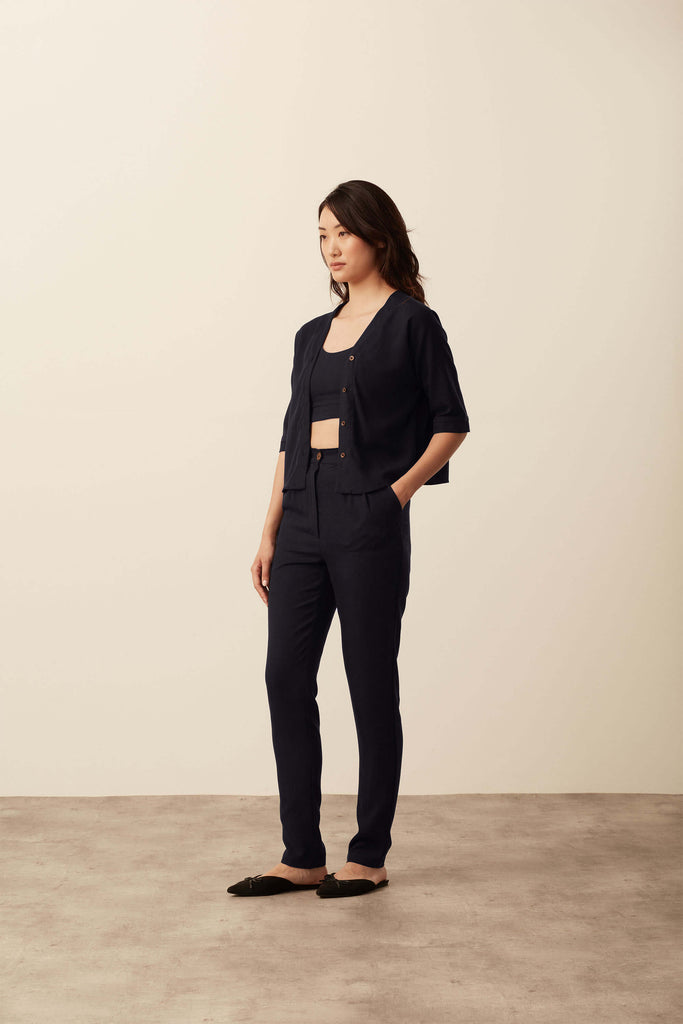 Model is looking to the side, wearing sustainable 100% Tencel trousers & boxy shirt, with 100% Organic Cotton Crop Top, her look is minimalist and timeless. Trousers have double pleats. Collection is for all new items, made to order and ethically produced