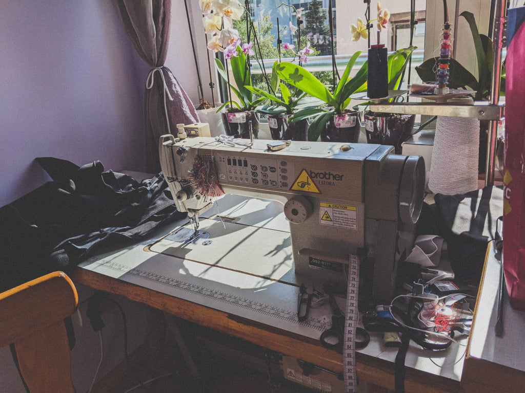 Home atelier with a sewing machine. Sun is pouring in and there are orchids on the window sill. This is where all of our clothes are made  - full transparent supply chain with fair pay for all involved. 