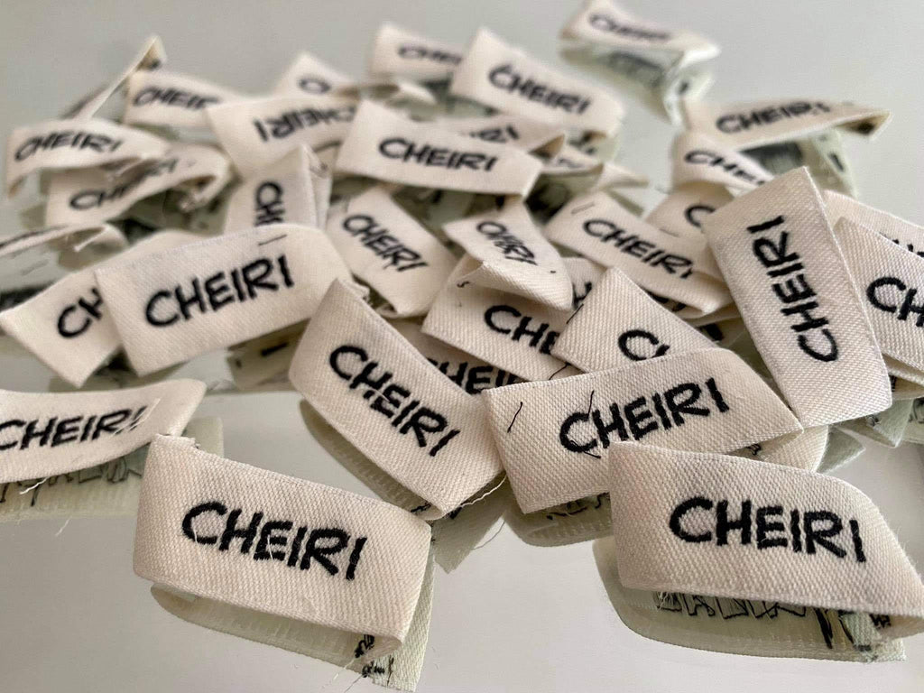 Brand labels with our logo: Cheiri. Made with 100% Organic Cotton, off white as these are not dyed. Sustainable down to the details